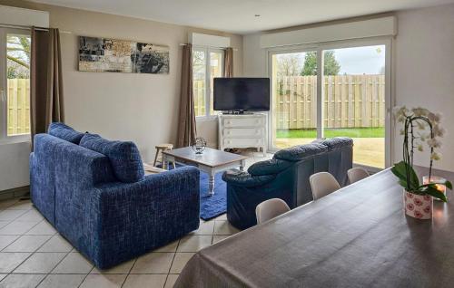 a living room with two blue chairs and a table at 3 Bedroom Nice Home In Desvres in Desvres