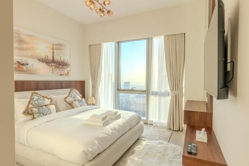 een slaapkamer met een groot bed en een groot raam bij 60th High Floor - full World islands, Downtown and Ocean View - high quality Design and Furniture - 2 Bedroom in Dubai
