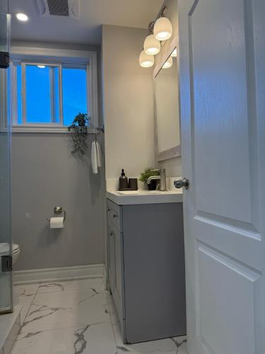 a bathroom with a sink and a mirror at Family-Friendly 3BR in Little Italy in Toronto