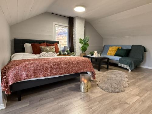 a bedroom with a bed and a couch at Family-Friendly 3BR in Little Italy in Toronto