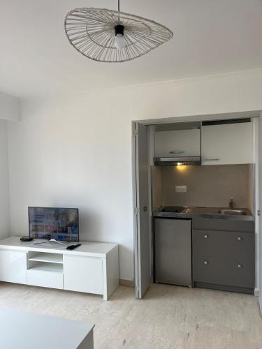 une cuisine avec une table blanche et un plafond dans l'établissement Studio dernier étage rénové, à Vallauris