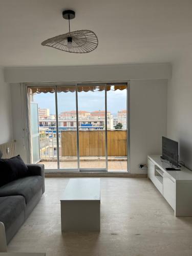 un salon avec un canapé et une grande fenêtre dans l'établissement Studio dernier étage rénové, à Vallauris