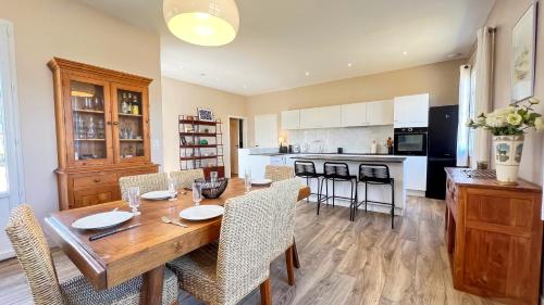 une cuisine et une salle à manger avec une table et des chaises en bois dans l'établissement Superbe villa à deux pas des commerces avec jardin, à La Couarde-sur-Mer
