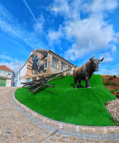 a statue of a cow standing in front of a building at Sofiamarholidays O Cantinho da Avó Bina in Moita