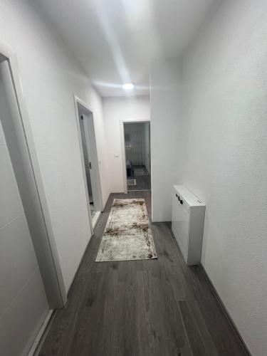 an empty room with a rug on a wooden floor at Liam Apartament in Prizren