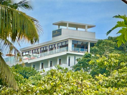 a building on top of a hill with trees at Coastline Mirissa Boutique hotel and Spa in Mirissa