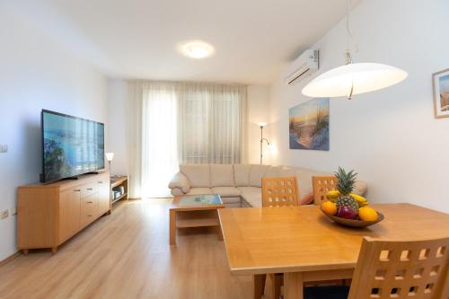 a living room with a dining room table and a television at Boki 2 one bedroom apartment in old town with balcony in Zadar