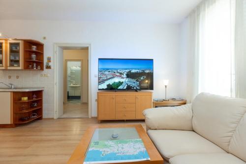 a living room with a white couch and a flat screen tv at Boki 2 one bedroom apartment in old town with balcony in Zadar