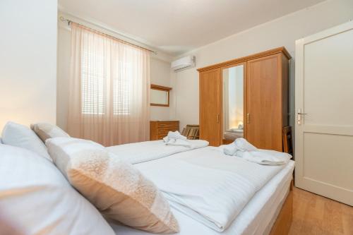 a bedroom with two white beds and a window at Boki 2 one bedroom apartment in old town with balcony in Zadar