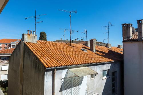 a building with an orange tile roof with antennas at Boki 2 one bedroom apartment in old town with balcony in Zadar