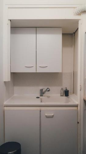 une cuisine avec des armoires blanches et un évier dans l'établissement Studio Caen quartier historique, à Caen