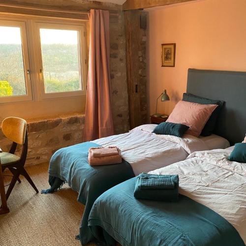 une chambre avec deux lits et une fenêtre dans l'établissement Les vins de Rouyré - Maison, 4 pers, grand jardin, bain nordique, à Sainte-Cécile-du-Cayrou