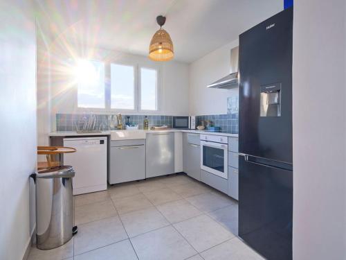 Il comprend une cuisine équipée d'appareils électroménagers blancs et d'un réfrigérateur noir. dans l'établissement Appartement Troyes - 3 Bedrooms Parking Free Netflix, à Troyes