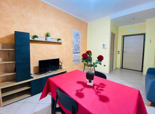 Una habitación con una mesa con un jarrón de flores encima. en Casa Via Dante, en San Cataldo