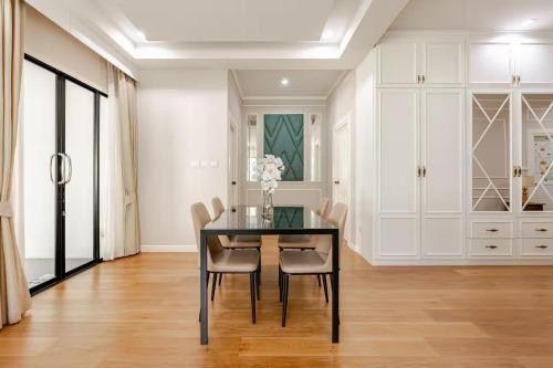 a dining room with a black table and chairs at Villa Siri 49 Luxury 4 BR Chiang Mai in Chiang Mai