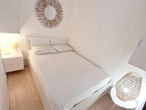 une chambre blanche avec un lit et un miroir dans l'établissement Appartement T2 avec Wi-Fi et parking à 200 m des plages - FR-1-316-342, à Six-Fours-les-Plages