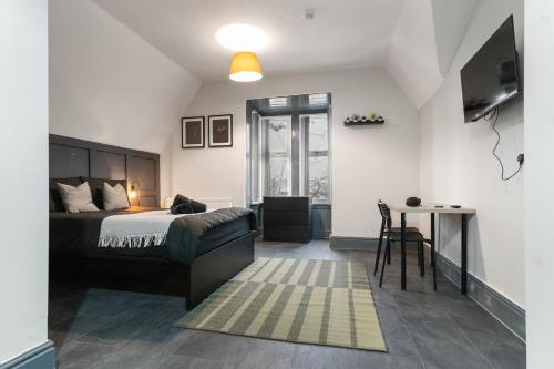 a bedroom with a bed and a table in it at Luxury Moseley Studio - 8 in Birmingham