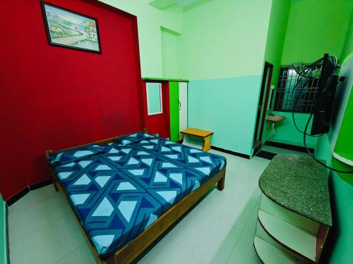 a bedroom with a bed and a red wall at SAlBALA LODGE - AC ROOMS WITH COOKING FACILITIES Near CMC in Vellore