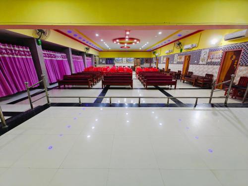 a dining room with red chairs and purple curtains at SAlBALA LODGE - AC ROOMS WITH COOKING FACILITIES Near CMC in Vellore