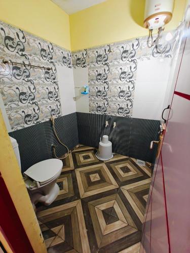 a bathroom with a toilet and a tile floor at SAlBALA LODGE - AC ROOMS WITH COOKING FACILITIES Near CMC in Vellore