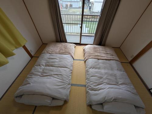 a bed in a small room with a window at Villa Hachiman-bori ヴィラ八幡堀 in Omihachiman