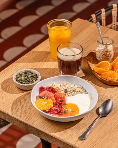 a wooden table with a plate of food and drinks at ibis Styles Montauban in Montauban