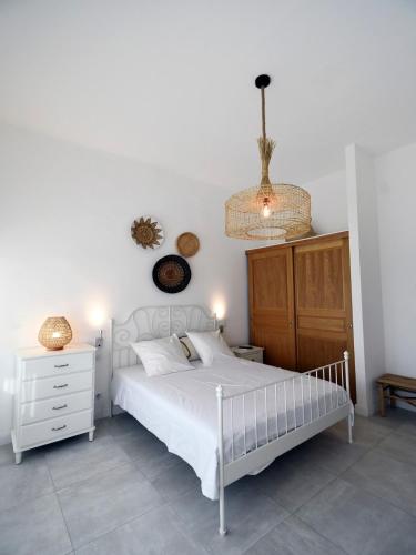 - une chambre avec un lit blanc et un lustre dans l'établissement Villa Josida - piscine & luxe à la plage - à 200m!, à La Croix-Valmer