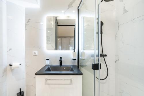 une salle de bain avec un lavabo et une douche dans l'établissement Chic & Elegant in Montorgueil, à Paris