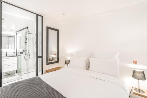 - une chambre blanche avec un grand lit et une douche dans l'établissement Chic & Elegant in Montorgueil, à Paris