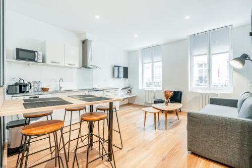 - une cuisine et un salon avec un comptoir et des tabourets dans l'établissement Chic & Elegant in Montorgueil, à Paris