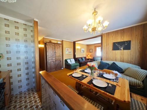 a living room with a table and a couch at Hostdomus - Good Vibes Apartment in Sestriere