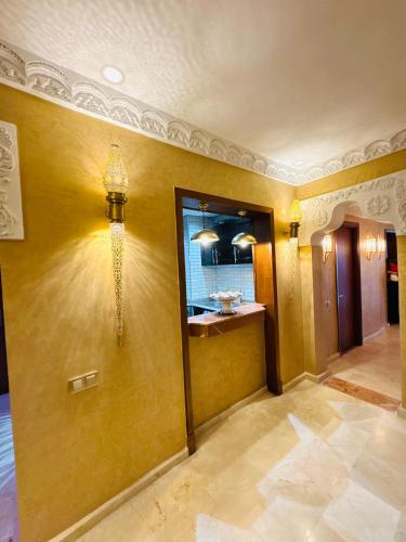 a room with a yellow wall with a mirror at Riad le marin Coucou beach in Agadir