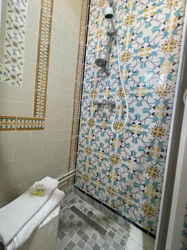 a bathroom with a shower with a tiled wall at Dar Morjana in Sousse