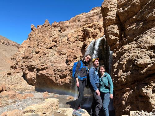 a group of people standing in front of a waterfall at Auberge & Restaurant Agoudal in Agoudal