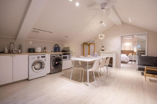 una cucina e una sala da pranzo con tavolo e lavatrice di GreeneStay Sindang DDP Seoul a Seul