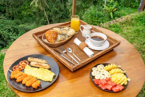 德格拉朗Muraya Villas in Ubud的餐桌,早餐盘和咖啡盘