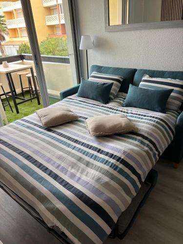 - un grand lit avec des oreillers dans la chambre dans l'établissement ABBAYE DU CAP, Jolie Studio Cabine , Cap D'Agde, au Cap d'Agde