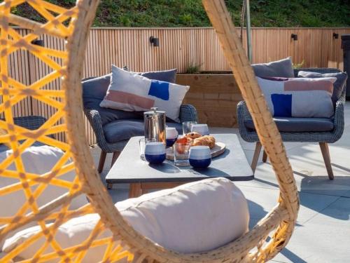 aicker swing chair with a table with a plate of food at Redwalls Luxury House in Dartmouth