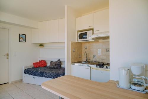 une cuisine avec des armoires blanches et un comptoir dans l'établissement Le Crystal Studio Terrasse Vue mer Direct plage, à Dinard