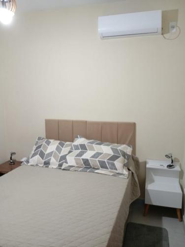a bedroom with a bed with a nightstand and a bed sidx sidx at Departamento 3- Pinheira in Praia de Cima (Pinheira)