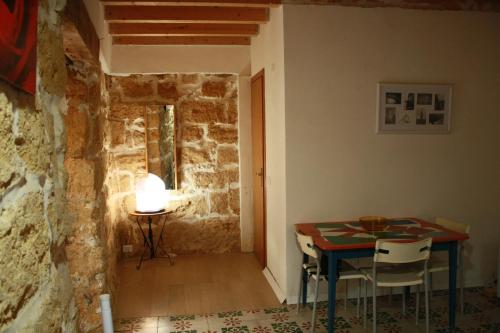 a dining room with a table and a room with a stone wall at Casa Lerux in Agrigento