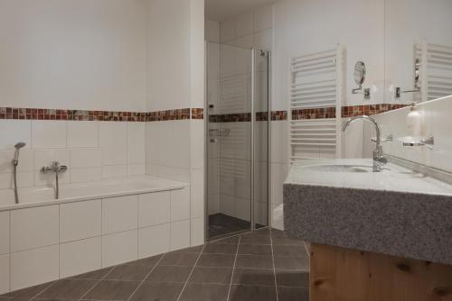 a bathroom with a sink and a shower at Hotel Marten - Ski-In & Ski-Out in Saalbach Hinterglemm