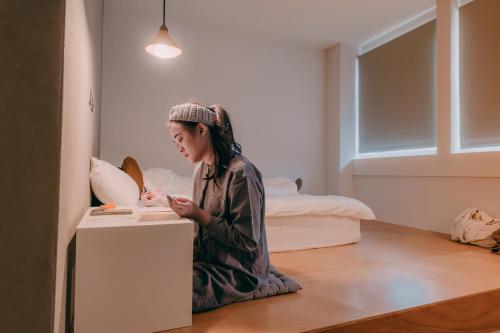 a woman sitting on the floor in a room at 又一天 Koh Tsit Kang in Suao
