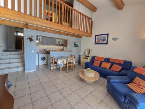 un salon avec des canapés bleus et une cuisine dans l'établissement Les Hauts de Bormes Mazet, à Bormes-les-Mimosas