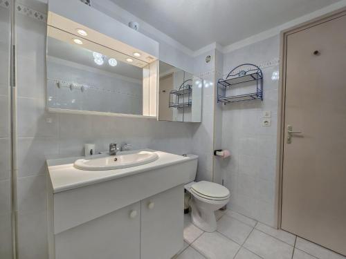 une salle de bain blanche avec un lavabo et des toilettes dans l'établissement Les Hauts de Bormes Mazet, à Bormes-les-Mimosas