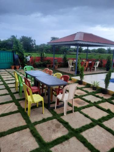 a patio with a table and chairs and a gazebo at Palm Villa and Cottage in Alibaug