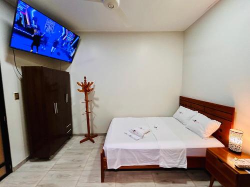 a bedroom with a bed and a flat screen tv at Habitación Céntrica en Iquitos - Casa Alemi 9 in Iquitos