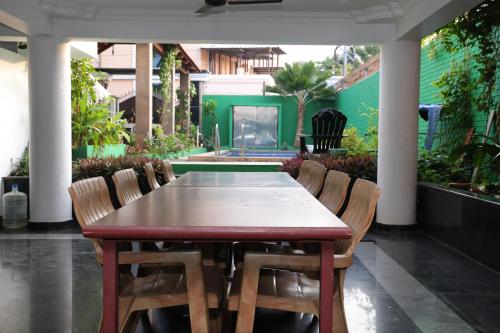 a wooden table and chairs in a garden at Villa Serenity Le Sejour Pondicherry in Kottakupam
