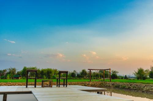 a picnic area with benches and a sky at ComeOn Stay&Sleep in Chiang Rai