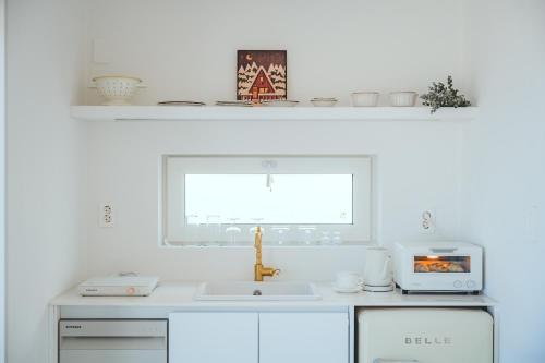 a white kitchen with a sink and a window at Byeolsai in Gyeongju
